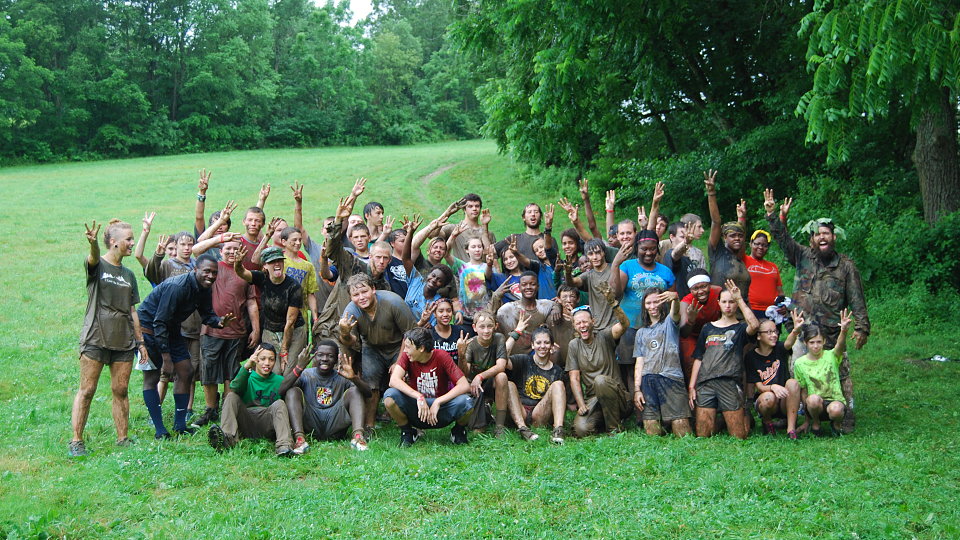 muddy group photo after obstacle course